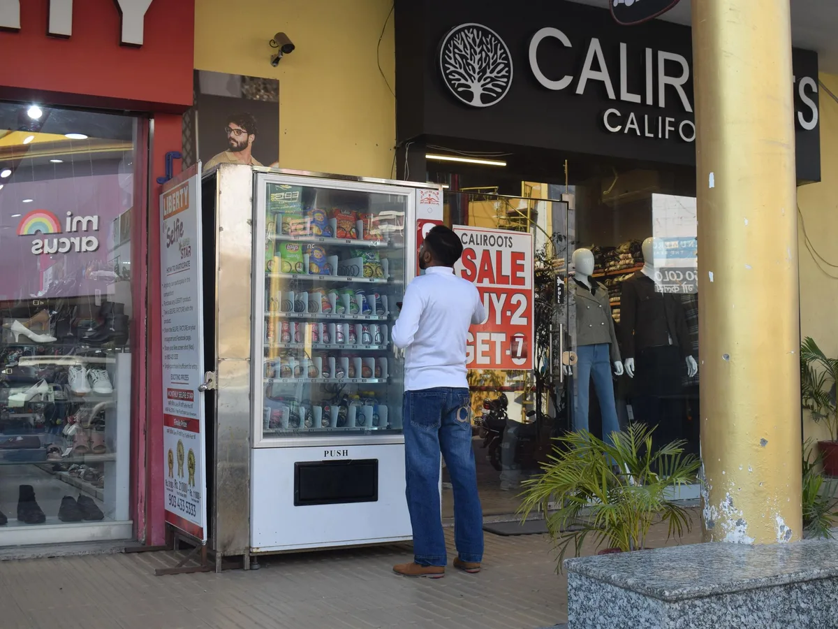 A modern vending machine standing alone in a dim, empty low-traffic corridor