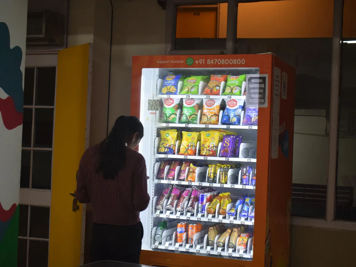 Vending operator restocking a modern machine during a routine route visit