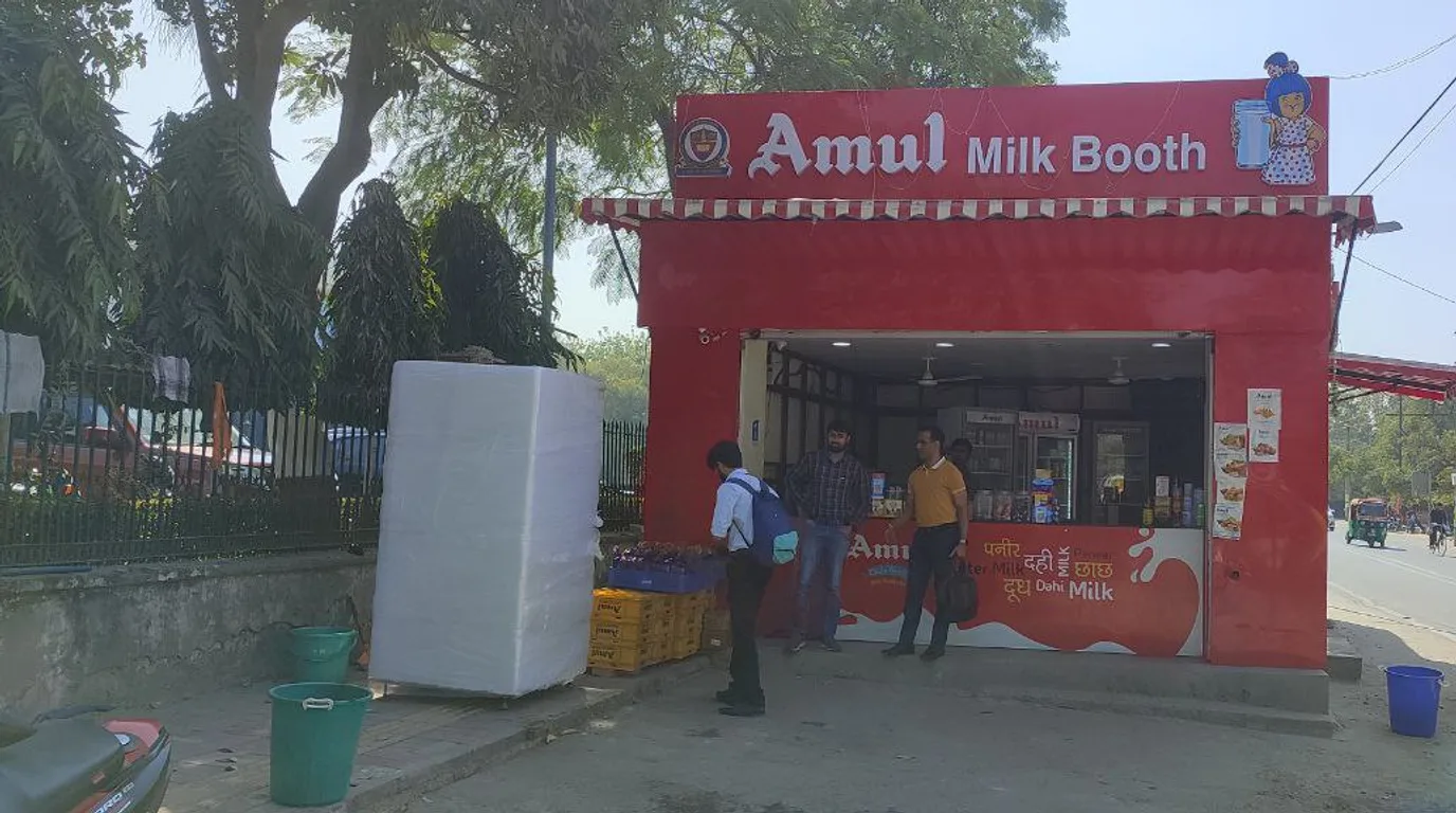 Excited students lined up at a book vending machine collecting freshly dispensed books