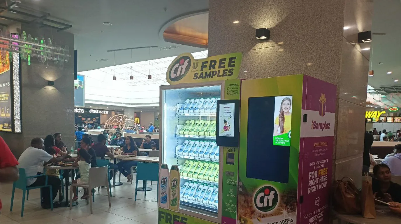 Sponsored vending machine wrapped in a brand design drawing attention in a busy lobby