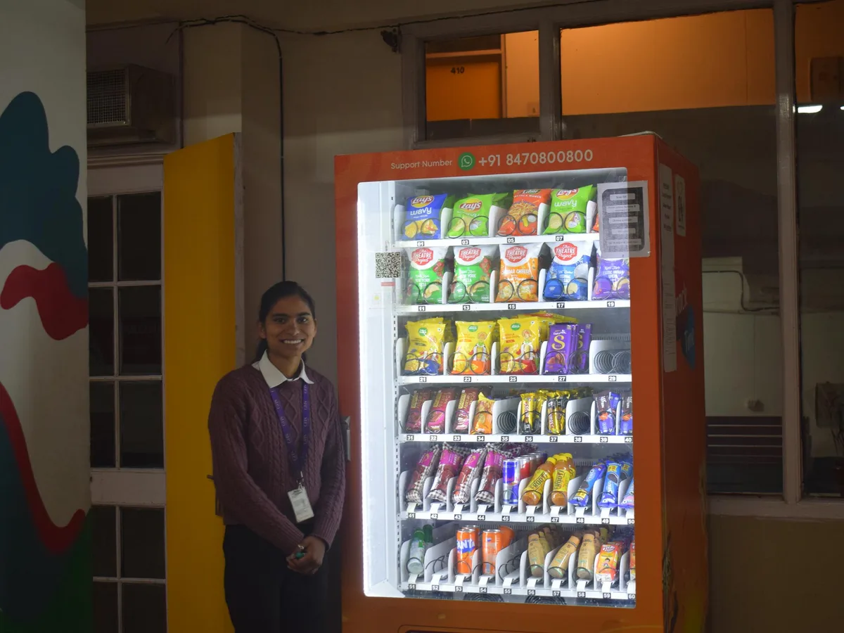 Hand inserting a banknote into the bill validator slot of a vending machine