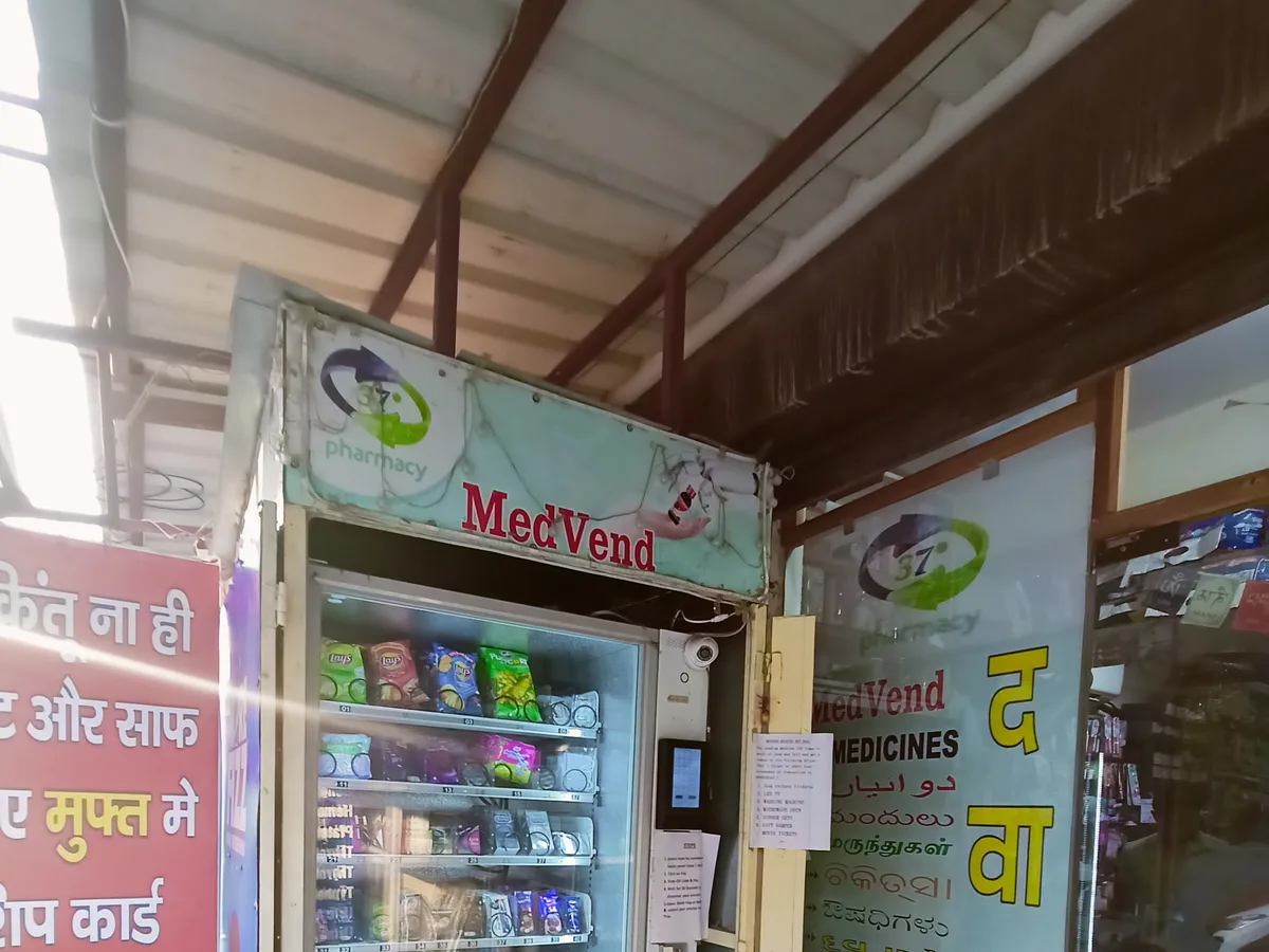 Vending machine screen glowing beside a nearly empty coin hopper