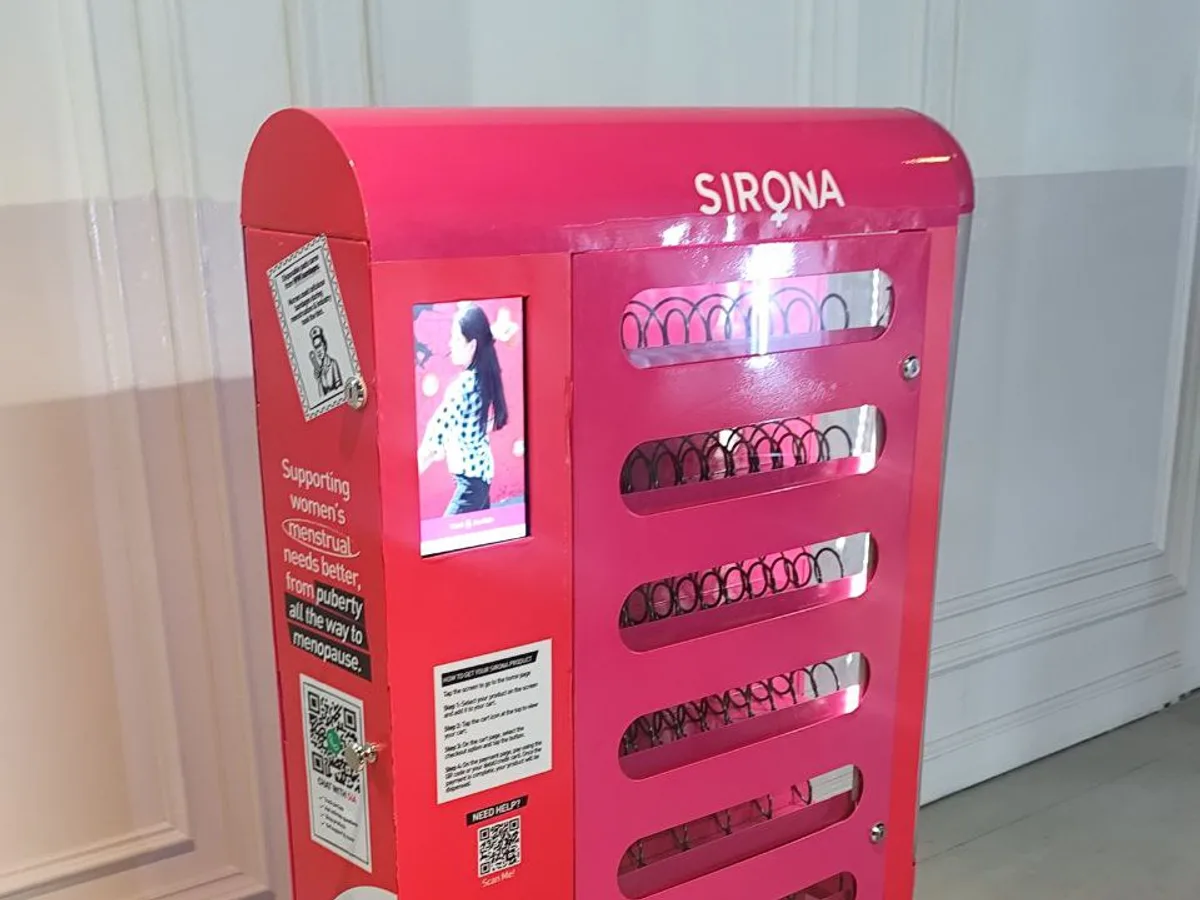 Hand inserting a chip card into the EMV slot of a vending machine's cashless reader