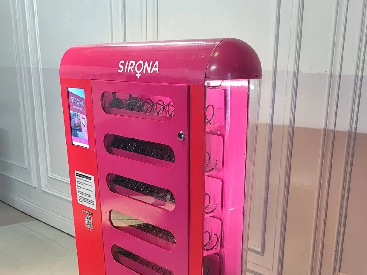 Smartwatch held near a vending machine's NFC reader to make a contactless payment