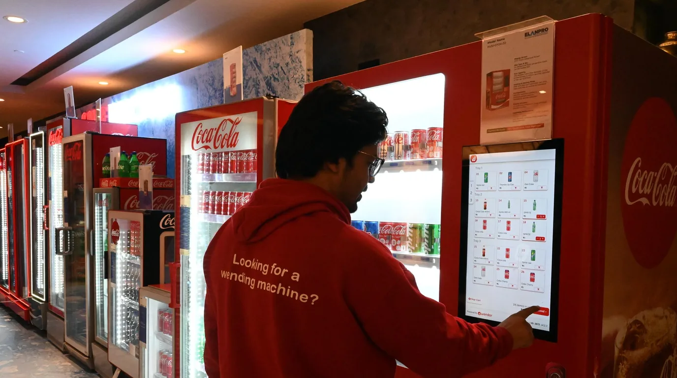 Manager and operator discussing placement beside a refrigerated fresh-food vending machine