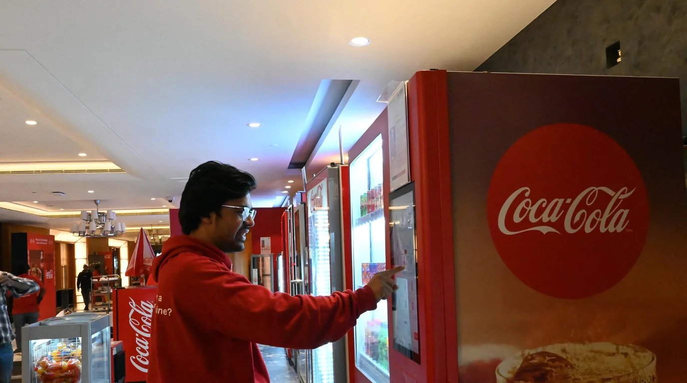 Customer completing a car purchase on a tablet in front of a glass car tower