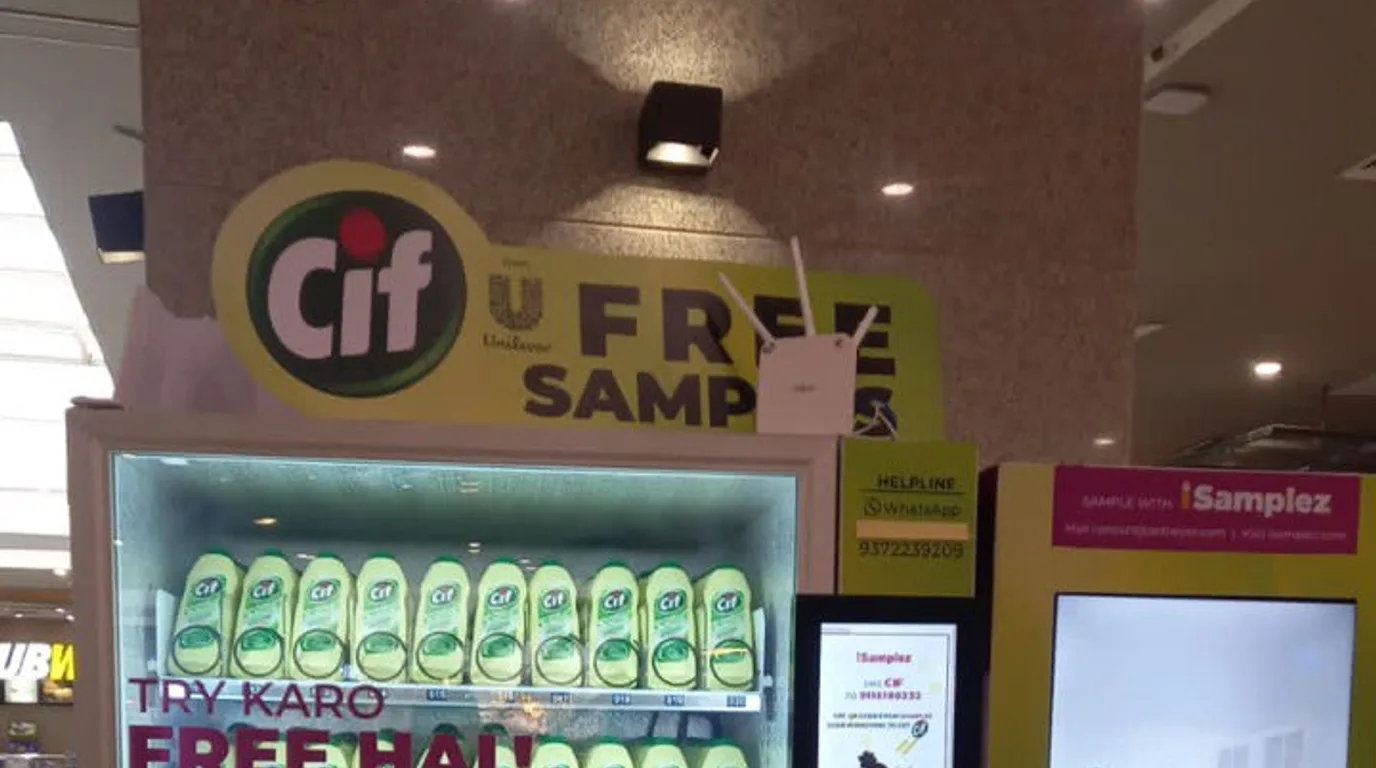 Operator reviewing a sales dashboard beside a vending machine with a UPI customer