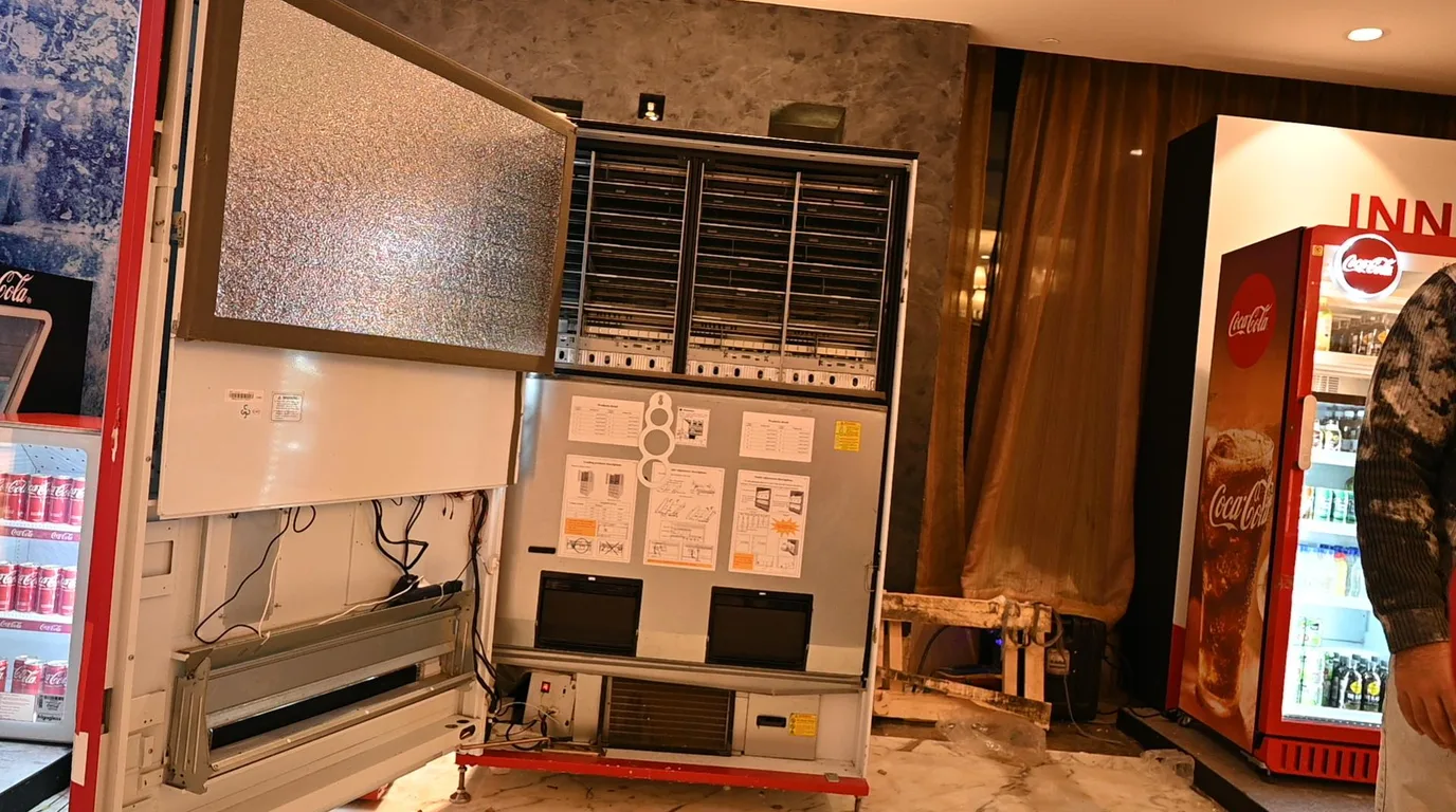 Technician setting eco-mode on an energy-efficient LED-lit vending machine