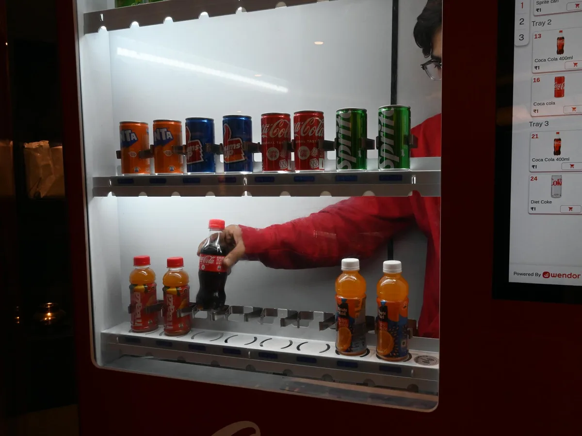 Buyer comparing three vending machines representing new, refurbished and used options.