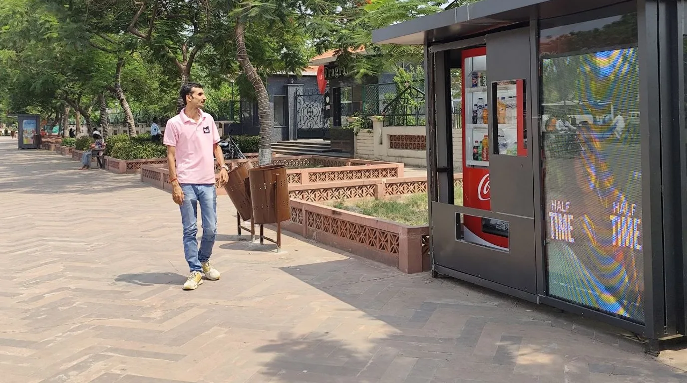 Technician performing scheduled preventive maintenance on an open vending machine.