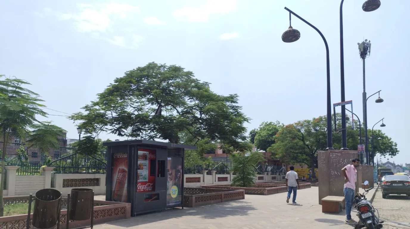 Moving equipment and a two-person team prepared beside a vending machine before relocation.
