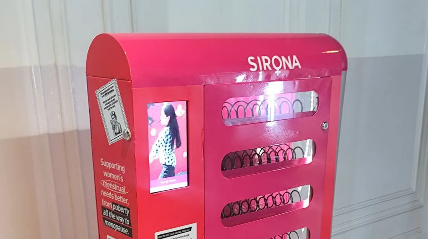 Health inspector reviewing a clean refrigerated vending machine with a clipboard