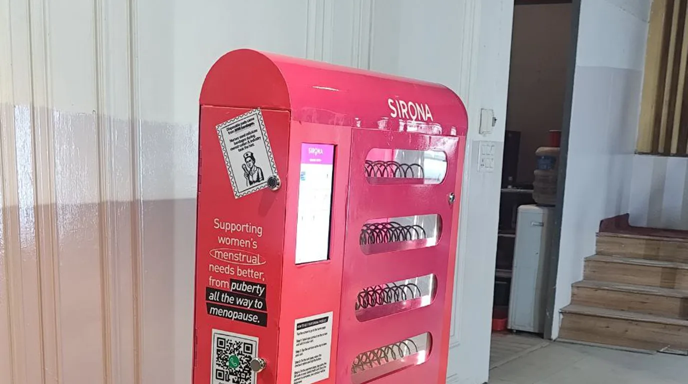 Hand tapping a contactless card on a sleek vending machine reader