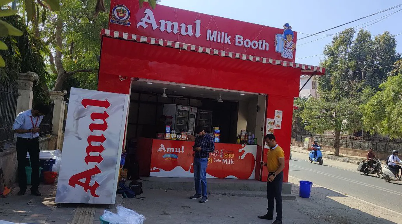 Three ice vending machines of different sizes shown side by side outdoors