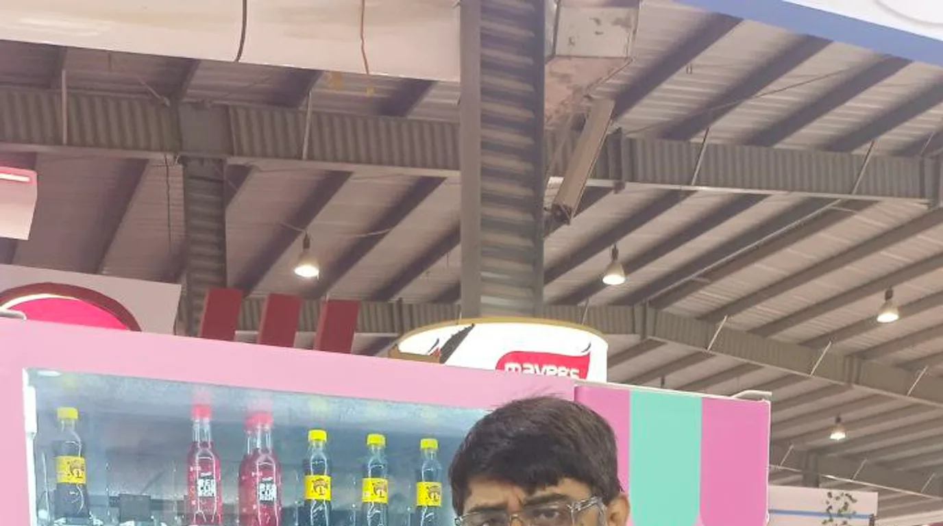 Ice vending machine at a busy sunny fuel station with passing customers