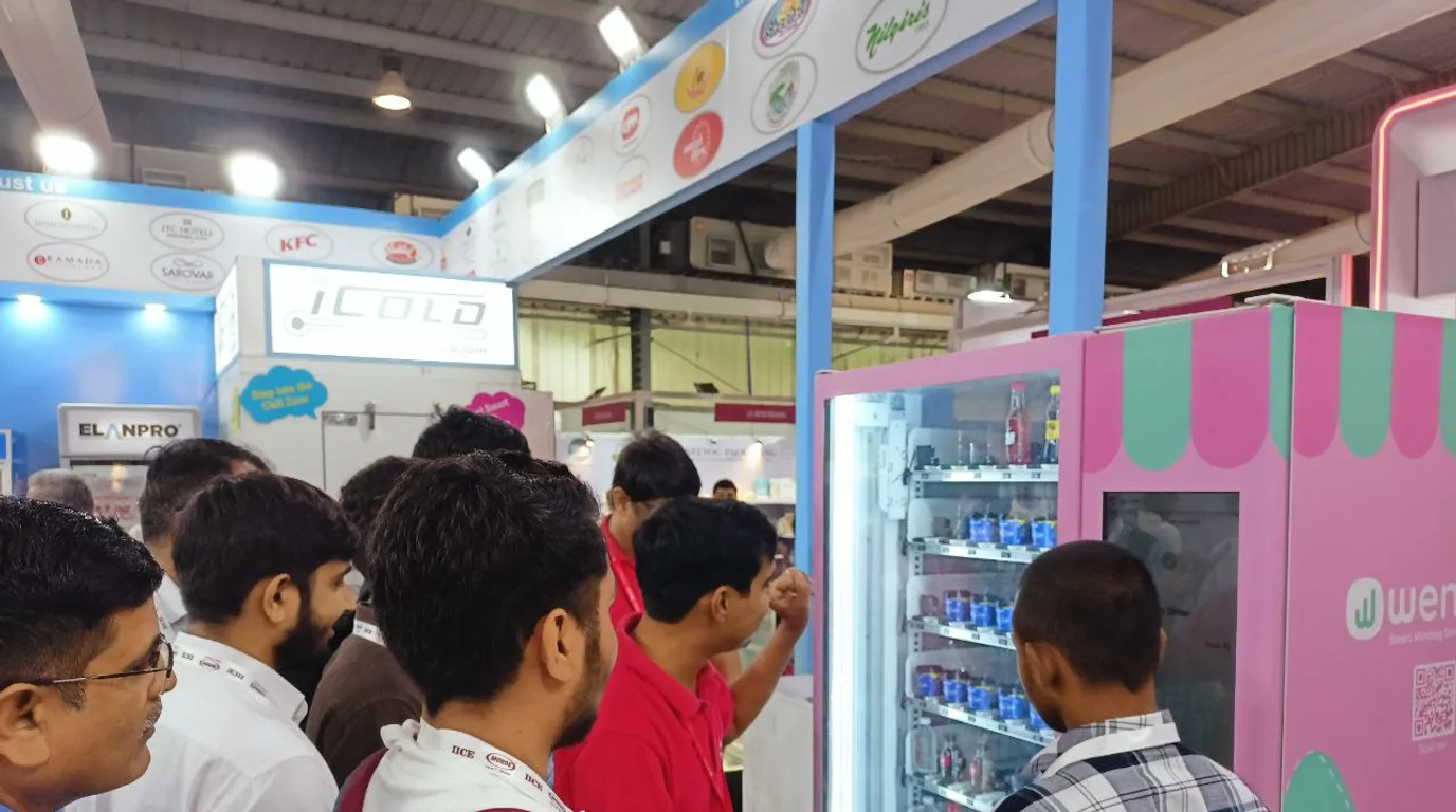 Workers connecting water and power to an ice vending machine with permits nearby