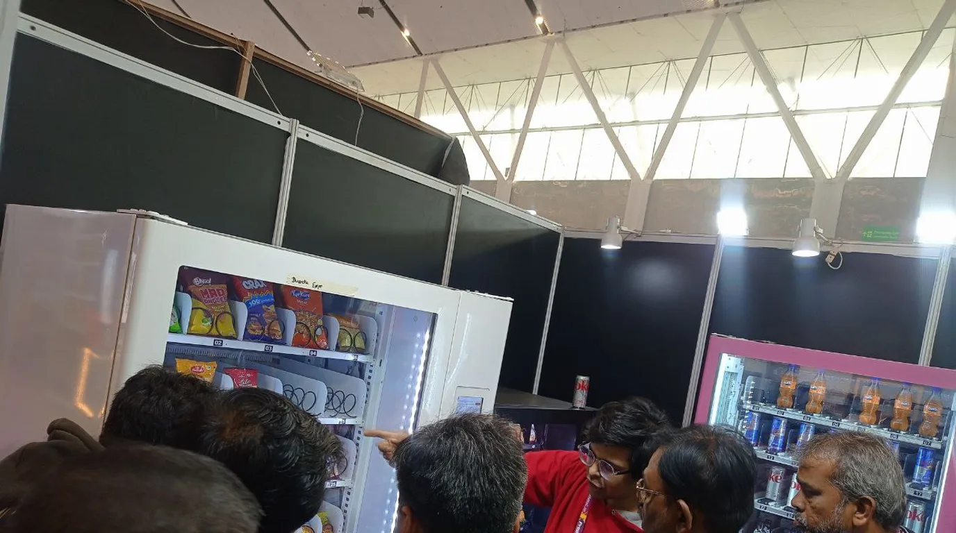 Operator refilling fresh batter into an idli vending machine in the morning