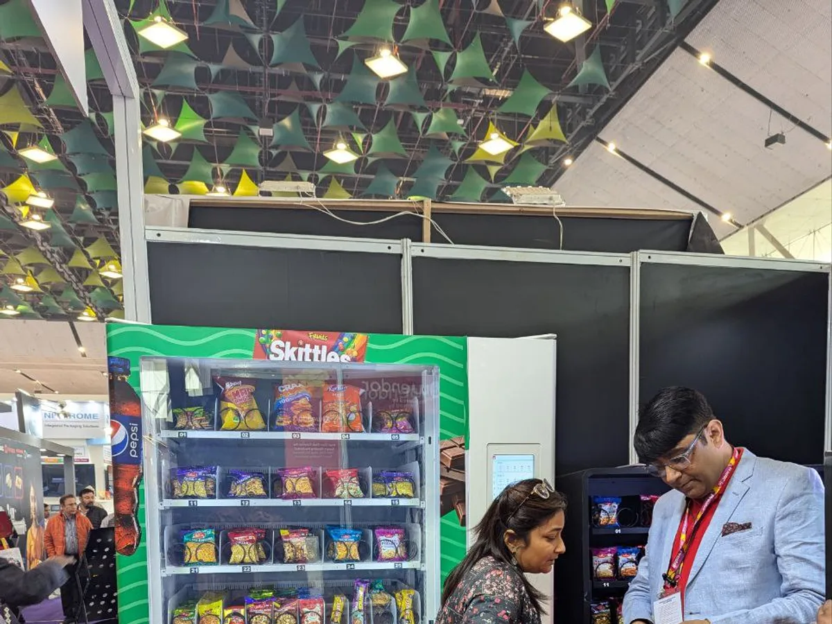Vending operator restocking a machine and checking inventory on a route