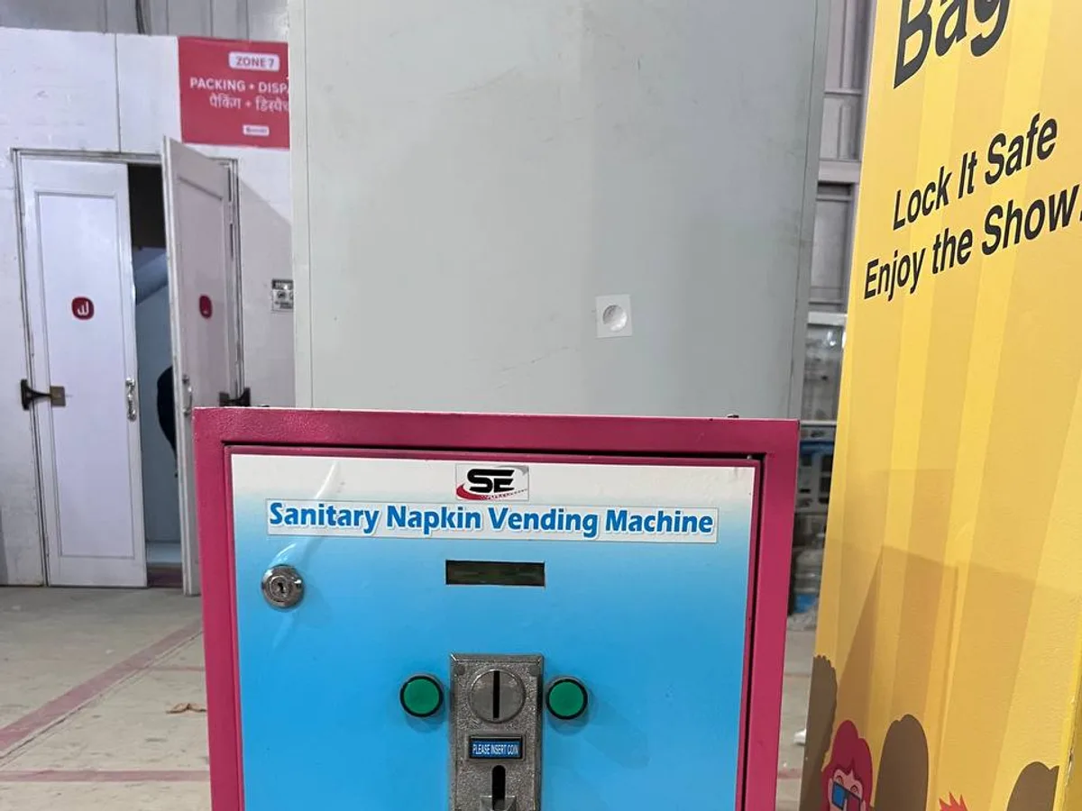 Close-up of a sanitary napkin machine panel showing touchless and digital payment features