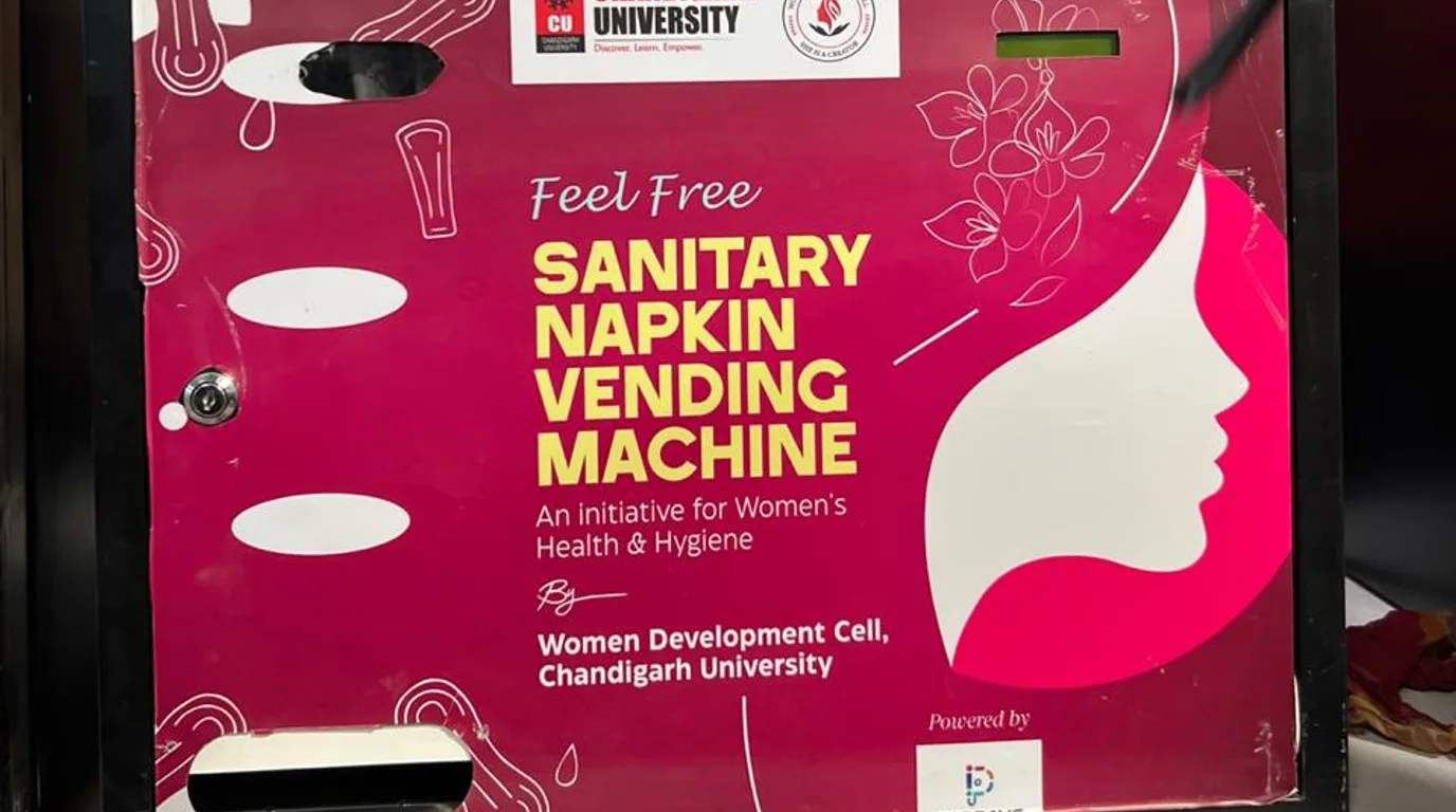 Sanitary napkin vending machine installed in an institutional washroom corridor