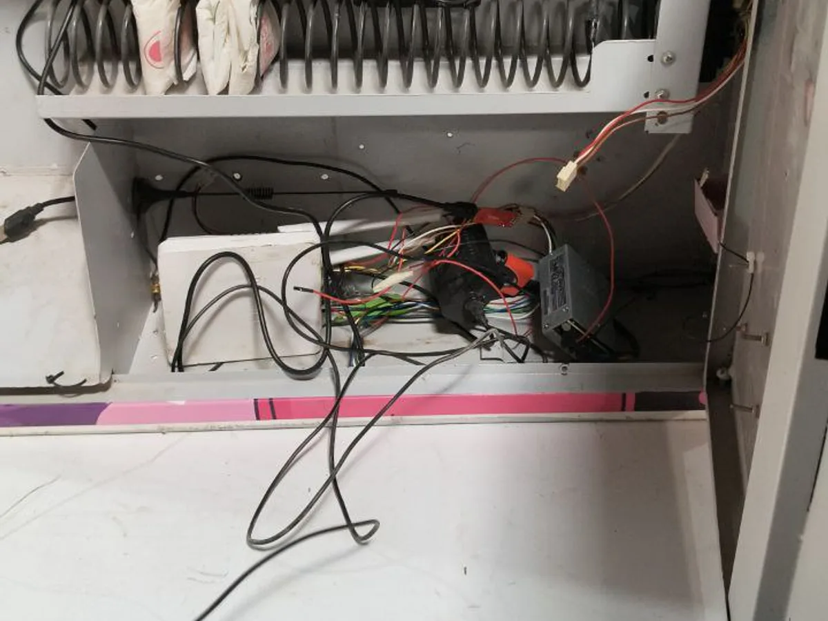 Service worker restocking a sanitary napkin machine with a refill dashboard tablet