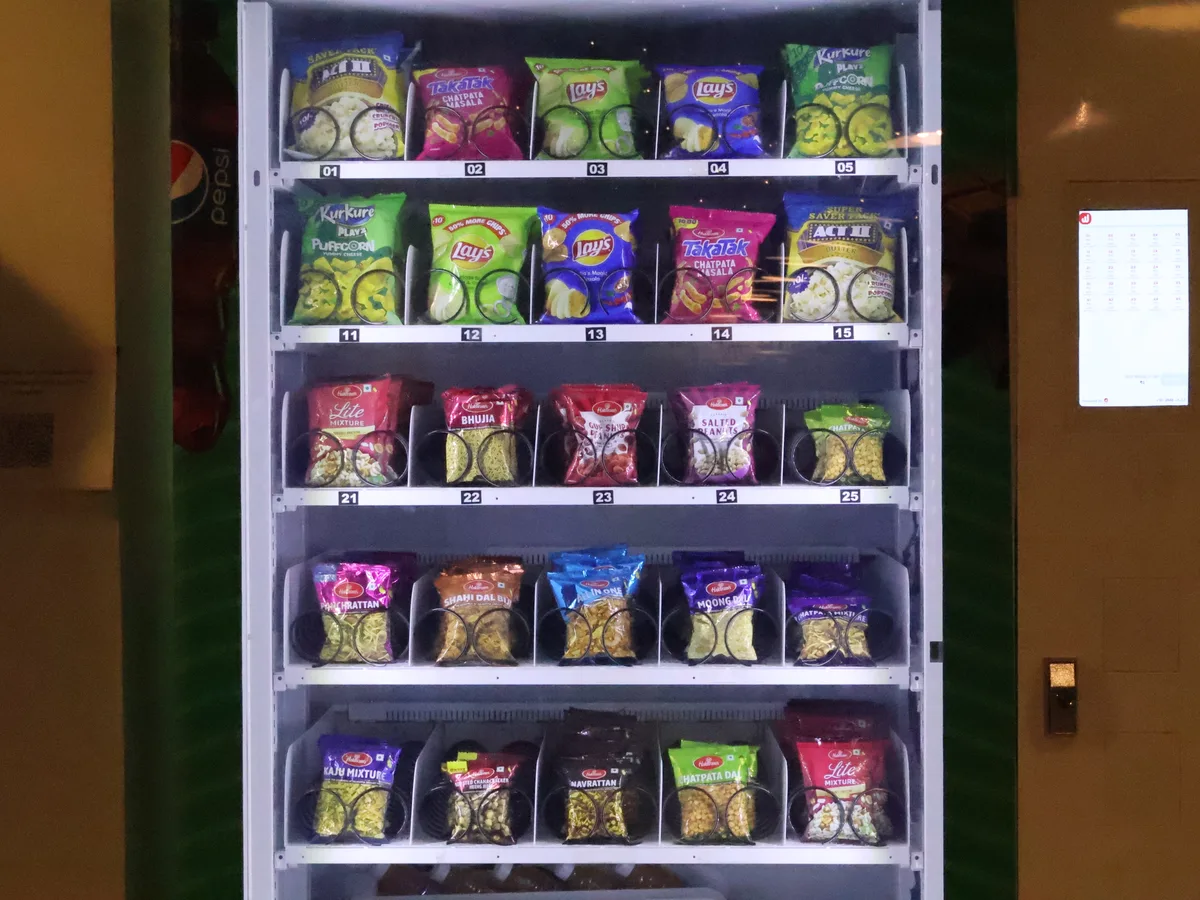 Fresh-food vending machine dispensing a hot Indian meal like idli or poha