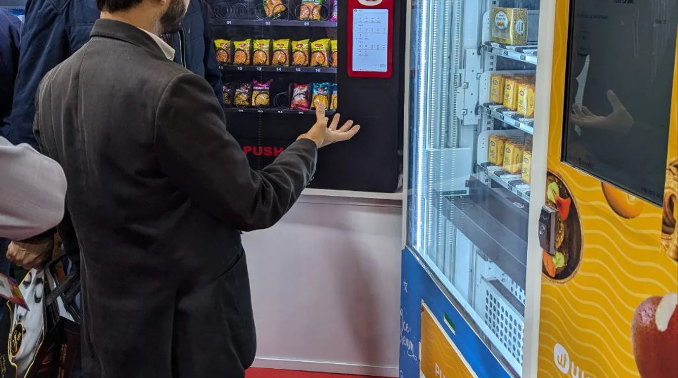 Person calmly reading the service details on a vending machine to report a stuck item
