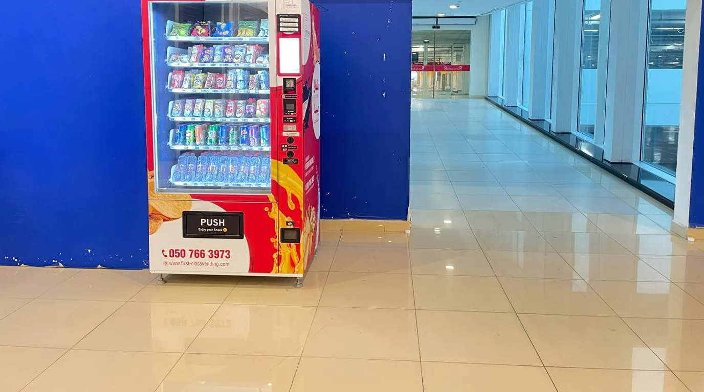 Modern vending machine in a busy upscale Dubai mall with shoppers