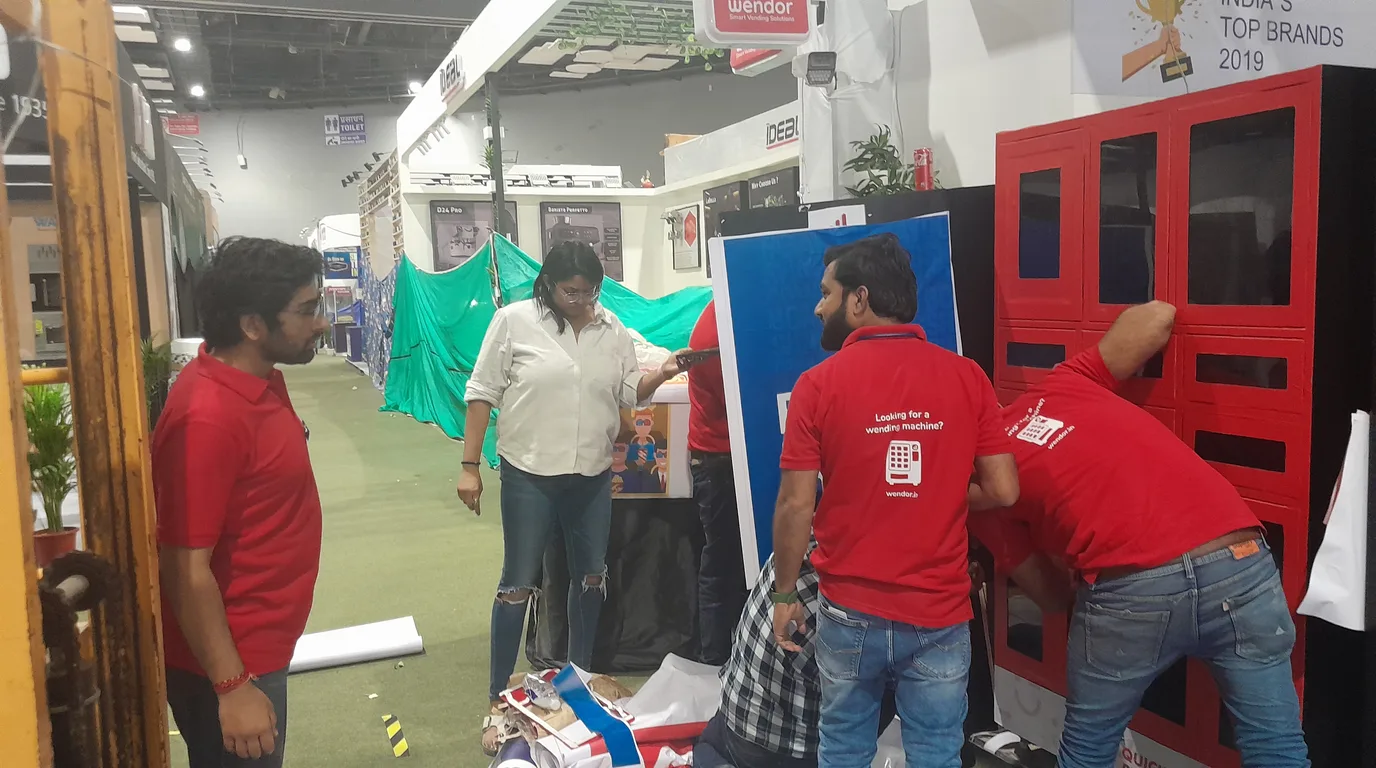 Operator and facilities manager shaking hands beside a serviced vending machine