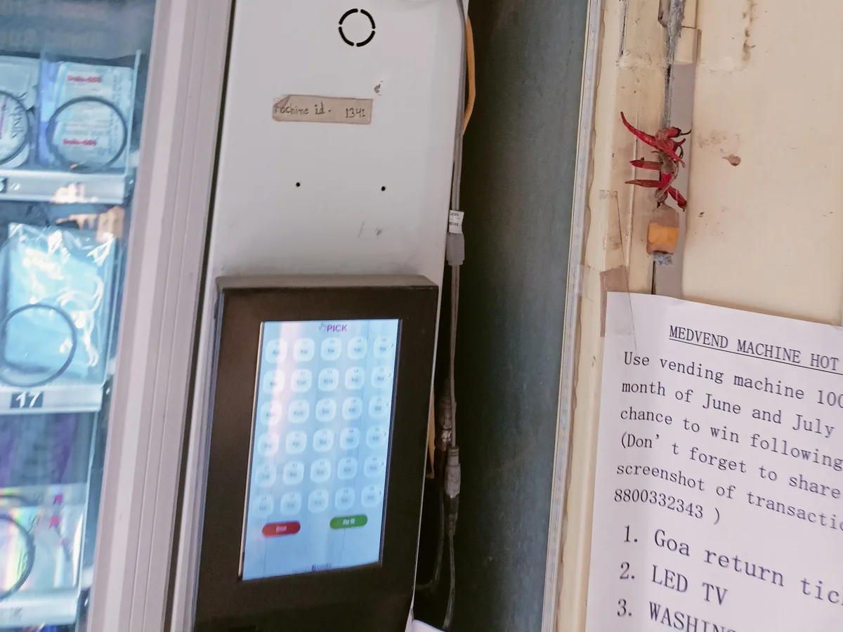 Open vending machine interior showing trays, coils, and a cashless payment module