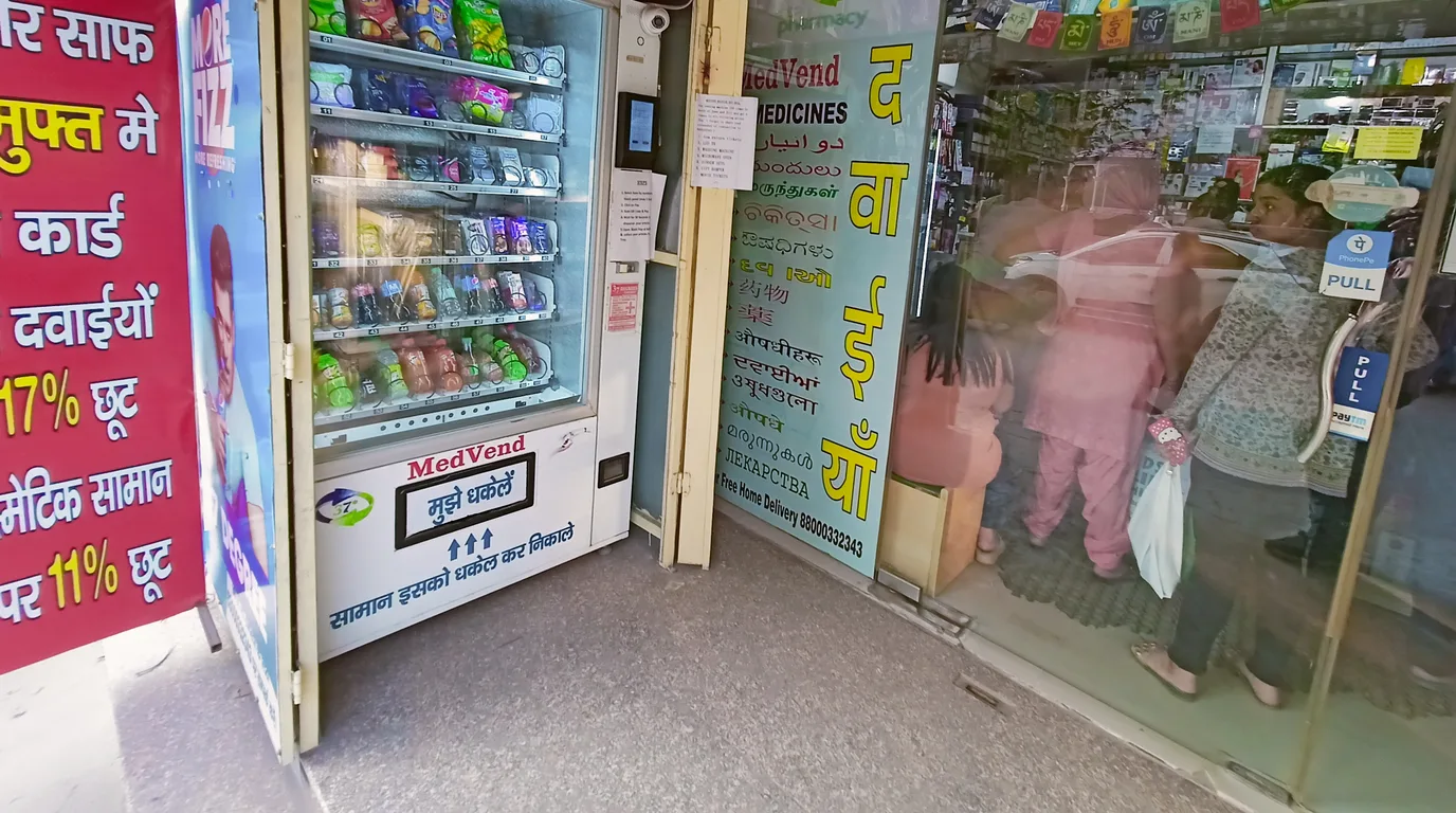 Confident entrepreneur standing beside a modern vending machine in a bright space