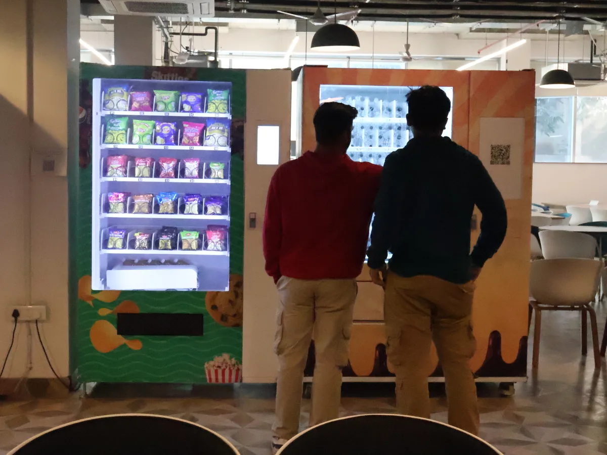 Flat-lay comparing fixed and variable vending costs around a small machine model