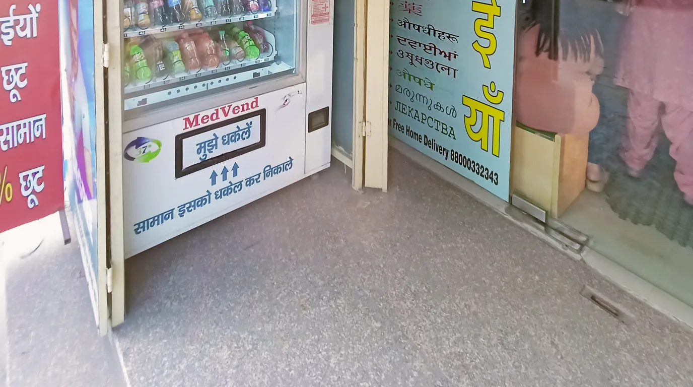 Finger pressing a button on a modern vending machine as a note enters the slot