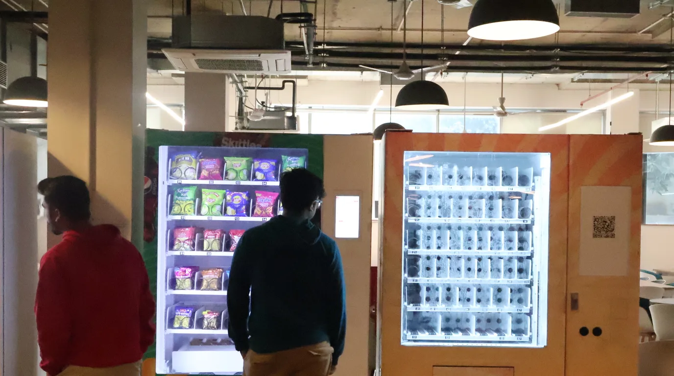 Flat-lay of layered permit documents beside a small vending machine model