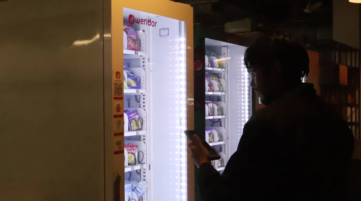Flat-lay of permit cards and a calculator beside a small vending machine model