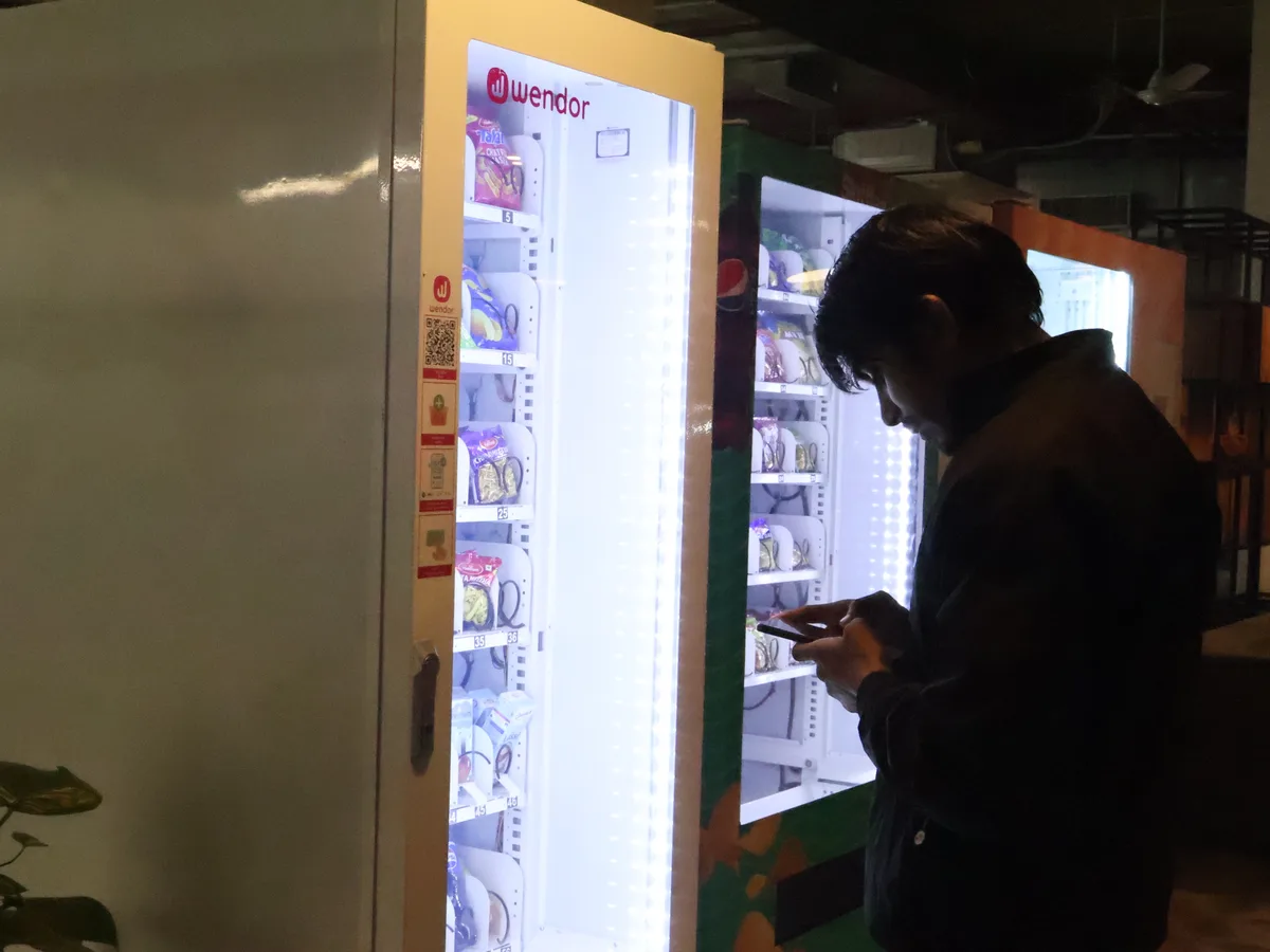 Four permit documents arranged around a vending machine model
