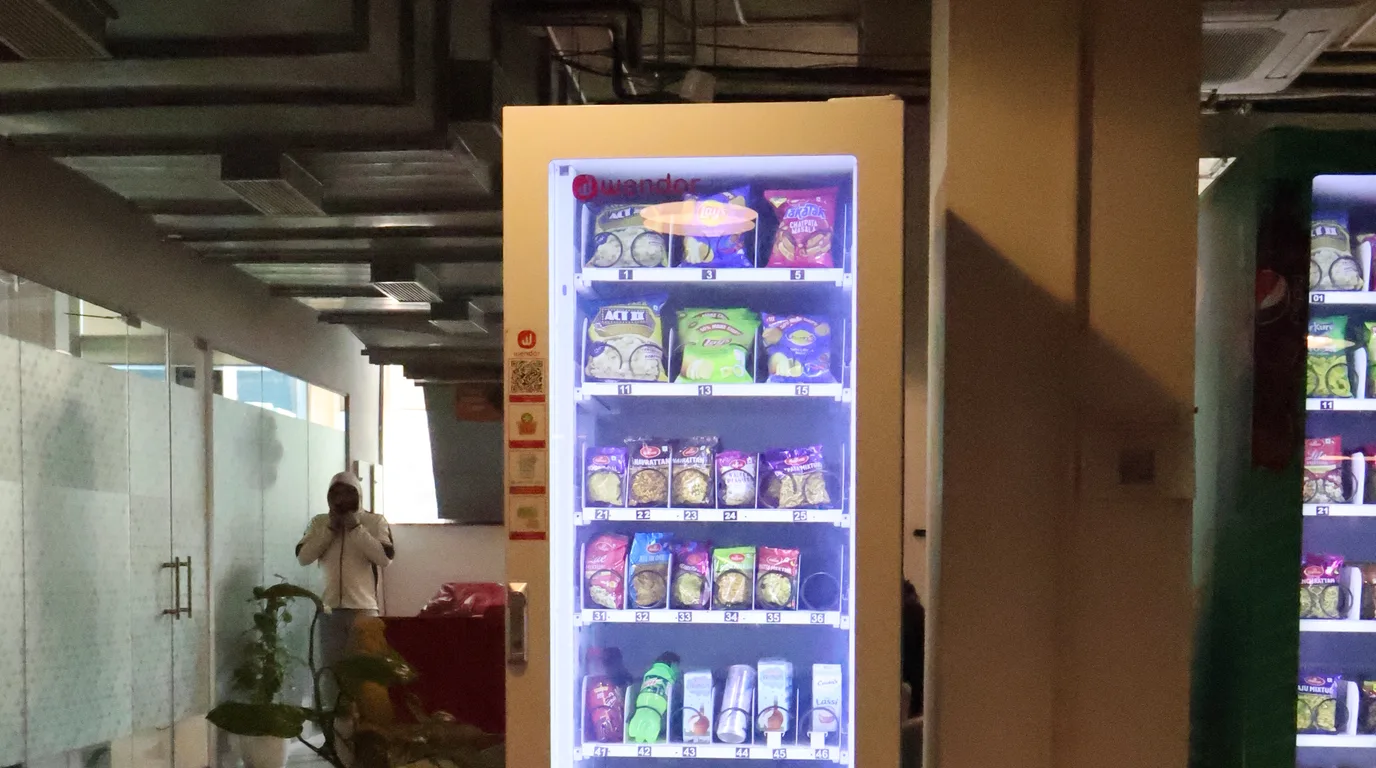 Overhead desk with a comparison grid, vending machine icons, and a calculator