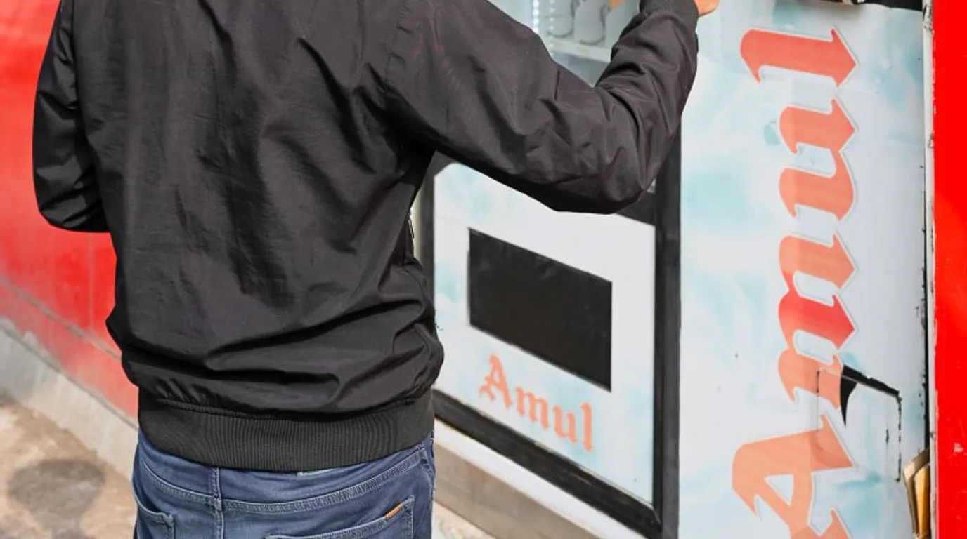 Operator planning a restock route on a tablet beside organized bulk product cases