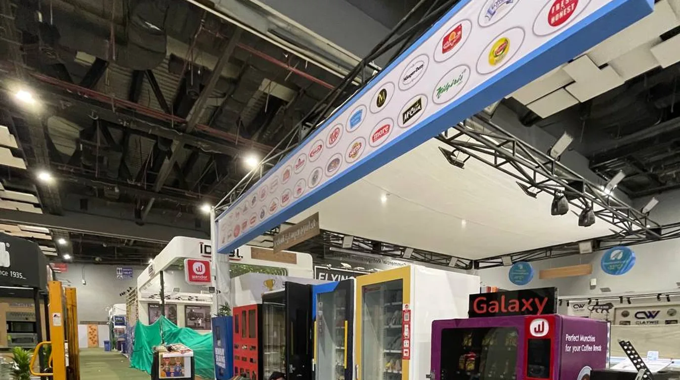 Versatile vending machine showing snacks, drinks, and electronics in a busy retail space