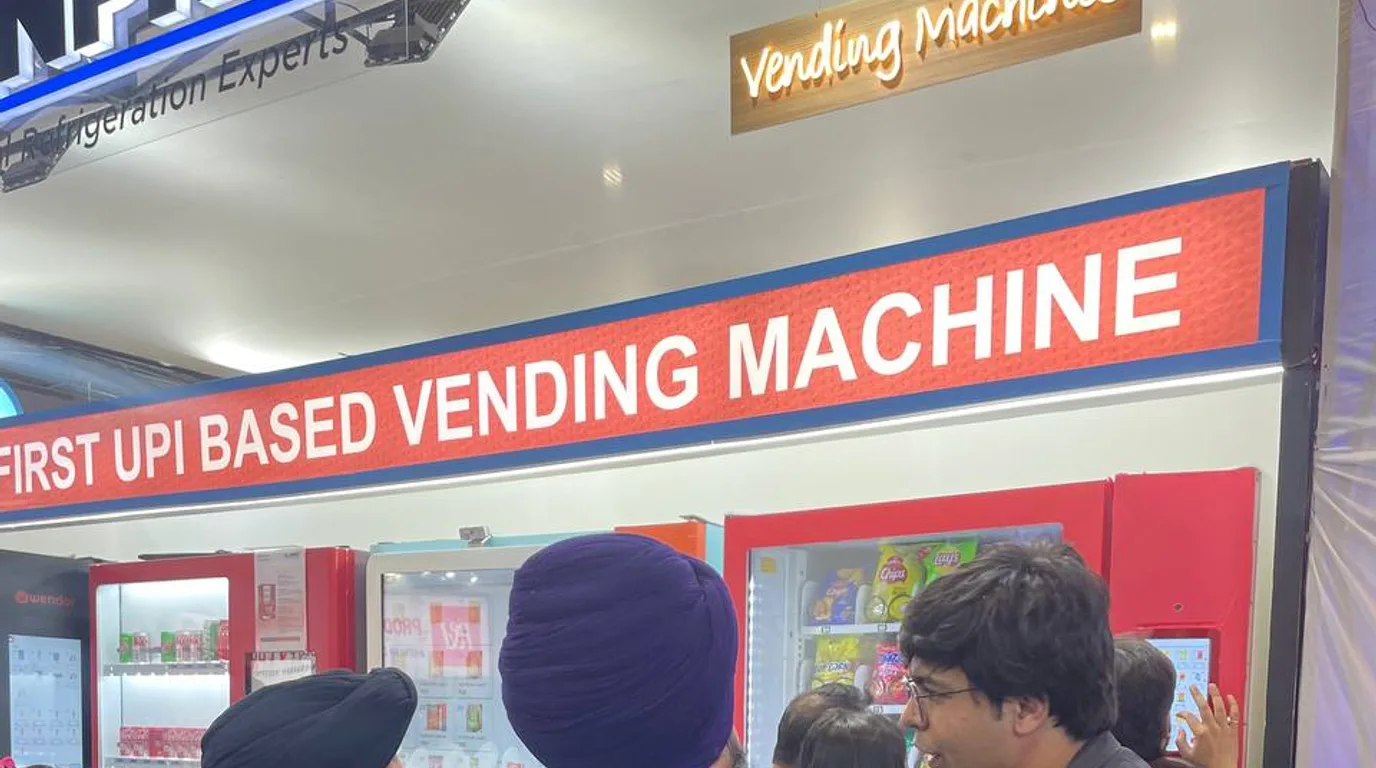 Facilities manager viewing a live multi-machine dashboard near an office vending machine