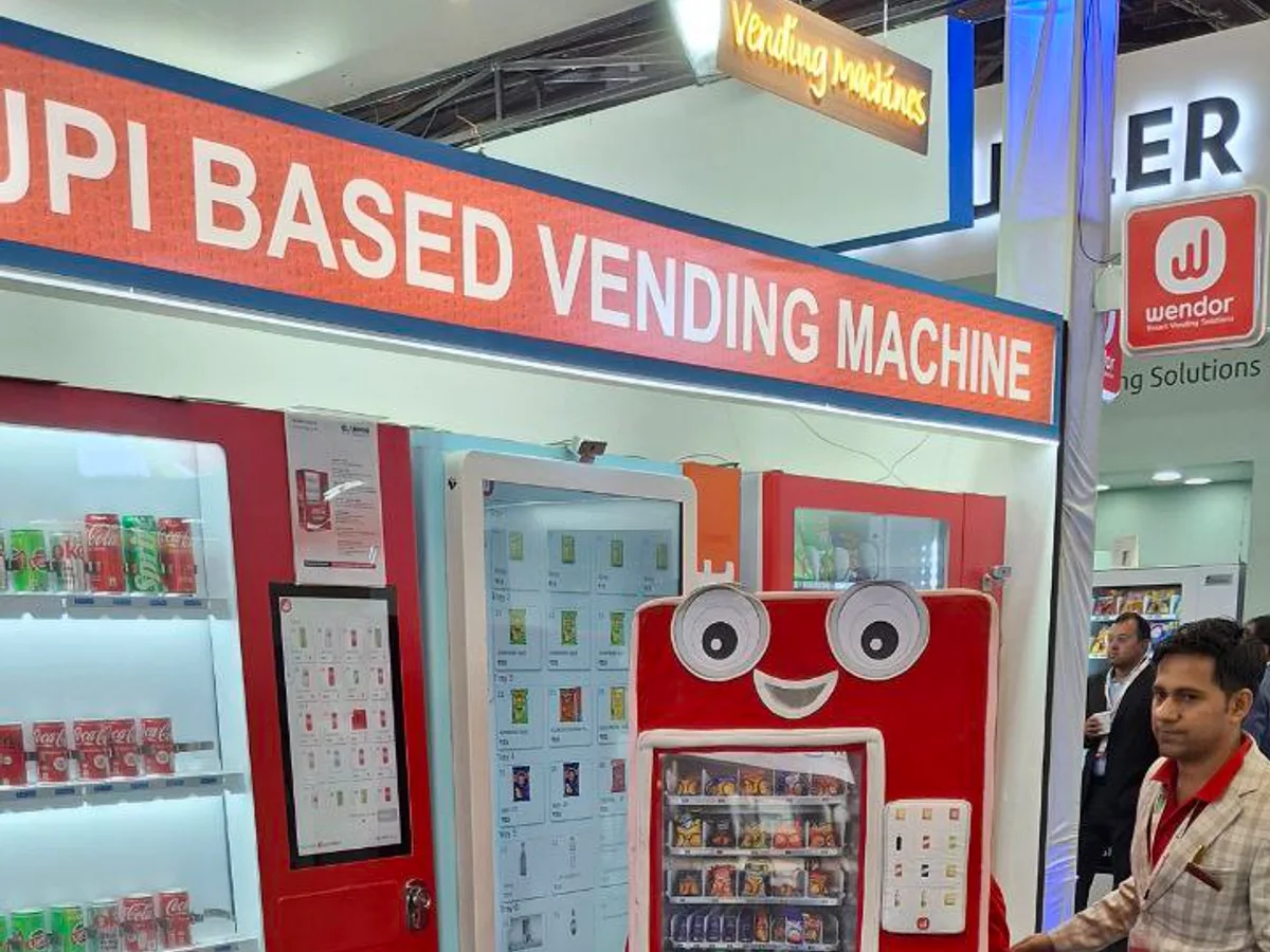 Vending operator reviewing a cloud dashboard beside a smart vending machine