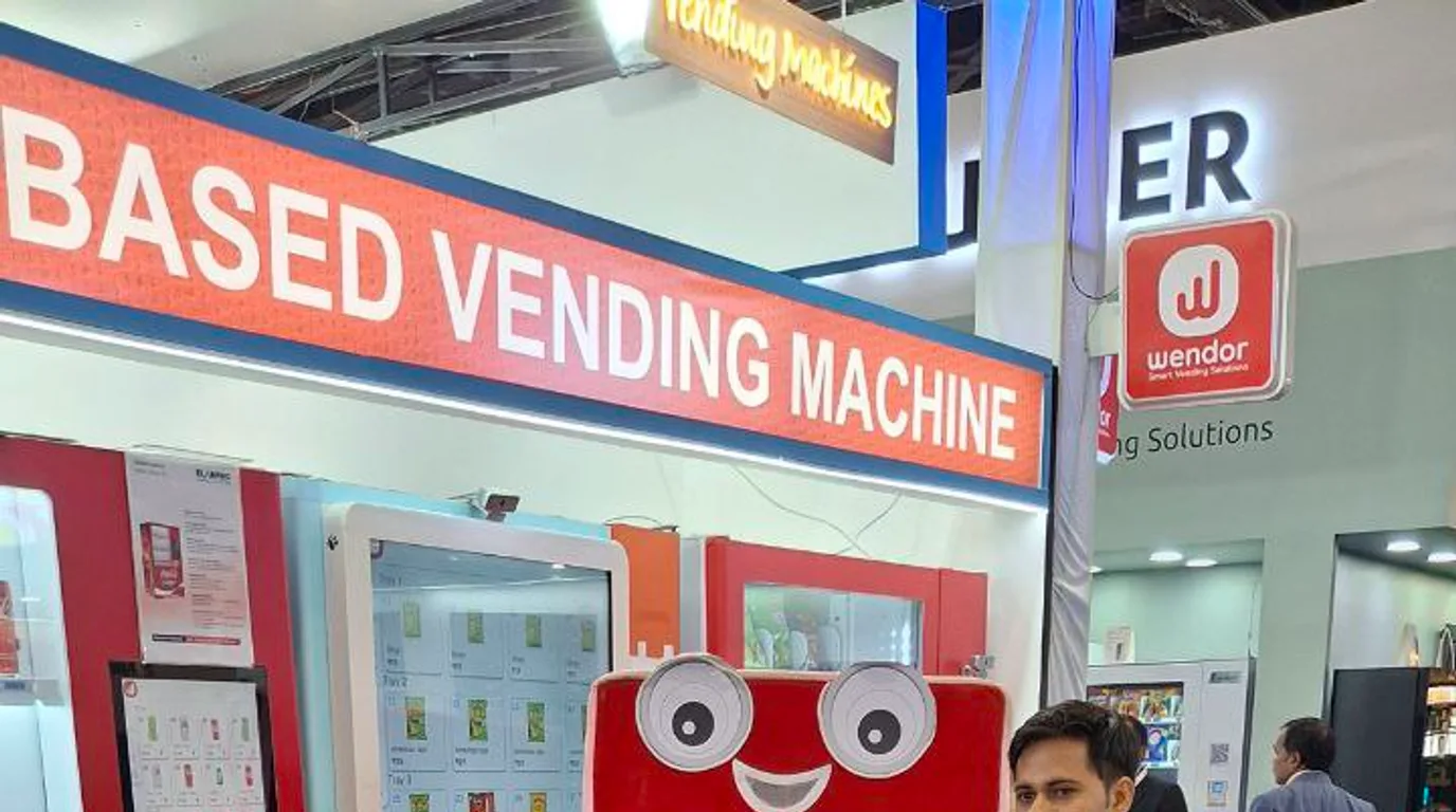 Busy corporate campus break area with people using smart vending machines